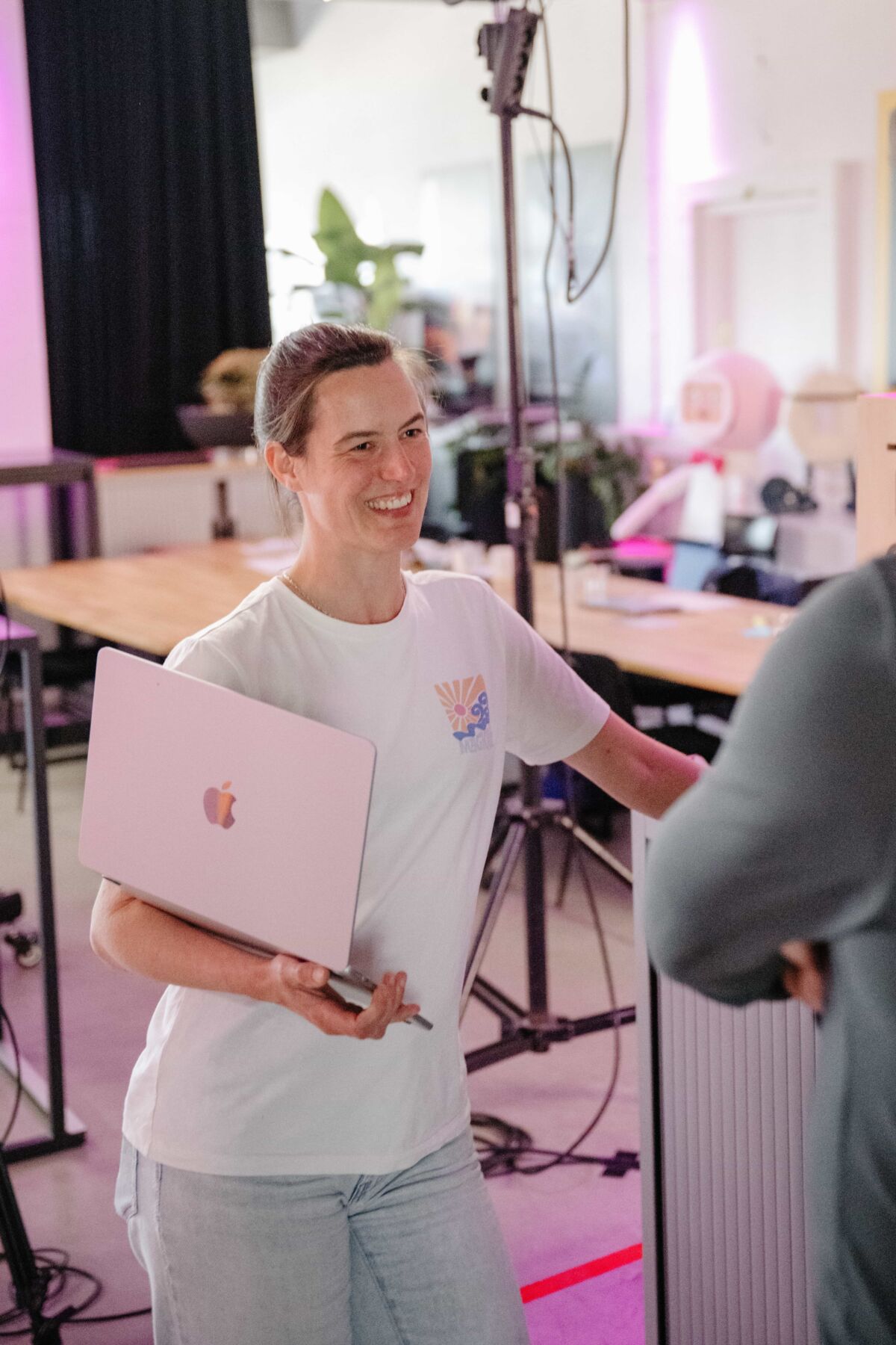 Lachende vrouw met een laptop op de arm