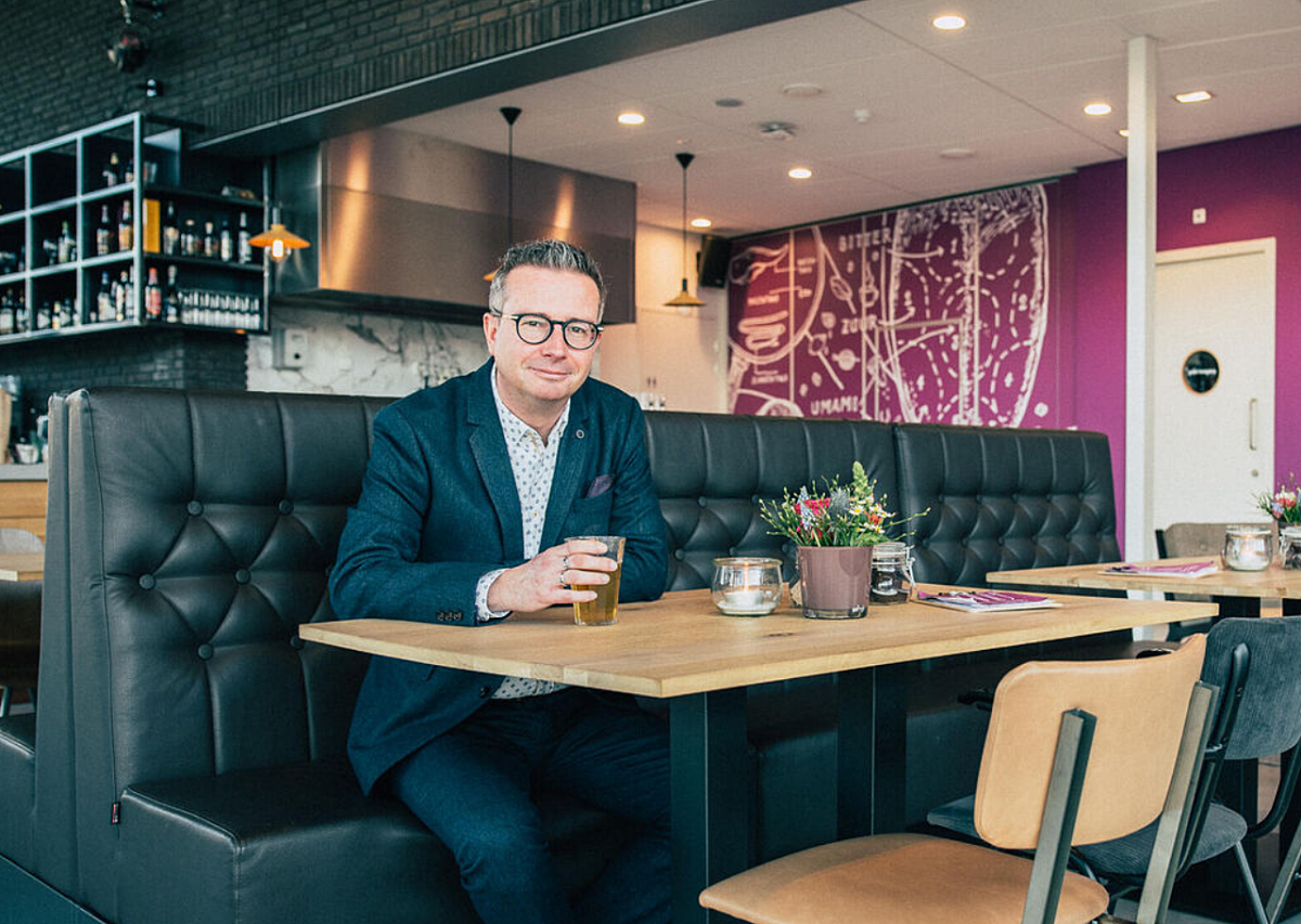 Directeur Jan-Hein Sloesen van theater de kring zit aan een tafel met een kopje thee in de hand.